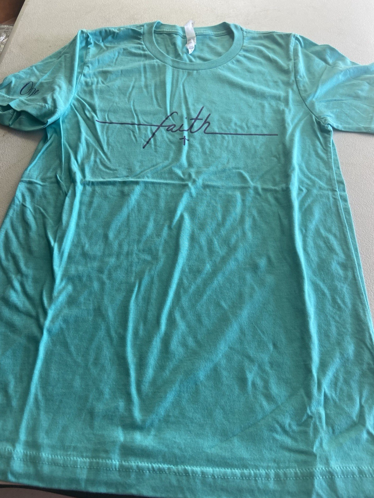Mint Green short sleeve t-shirt with Purple “Faith” logo