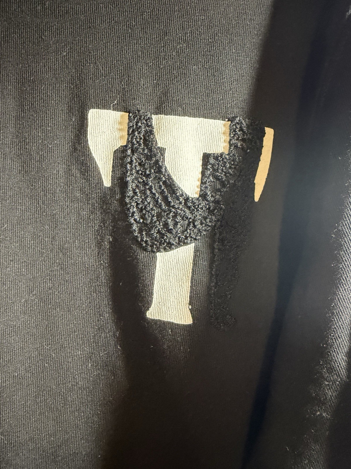 Tenaciti Studios t-shirt features a large fuzzy “T” logo on the right chest SZ S